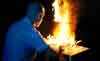 A male sex addict uses a laptop while it is engulfed in flames
