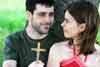 Christian couple struggling with addiction praying by a tree with a cross