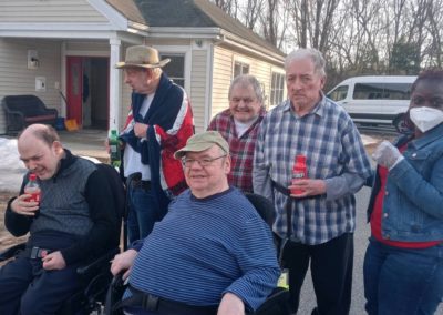 Group Home Members Sitting Outside In Front Of Van