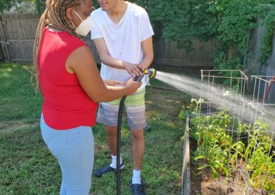 Group Home Members Watering Flowers