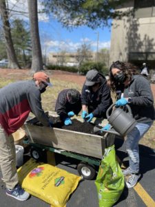 Group Of People Planting Outdoors With Masks On for Earth Day