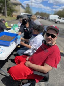 Man Outside Sitting A Table With Group Of People