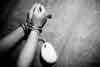 Hands and arms of sexually addicted male symbolically bound by cord of computer mouse.
