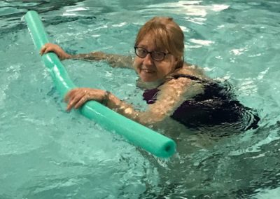 Woman Swimming with pool noodle